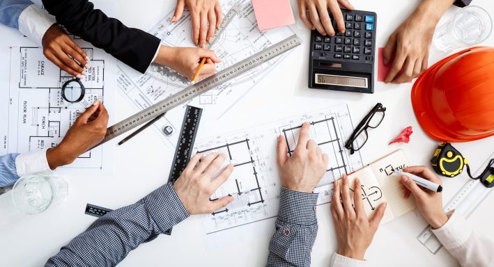 Picture of businessmen's hands on white table with documents and drafts